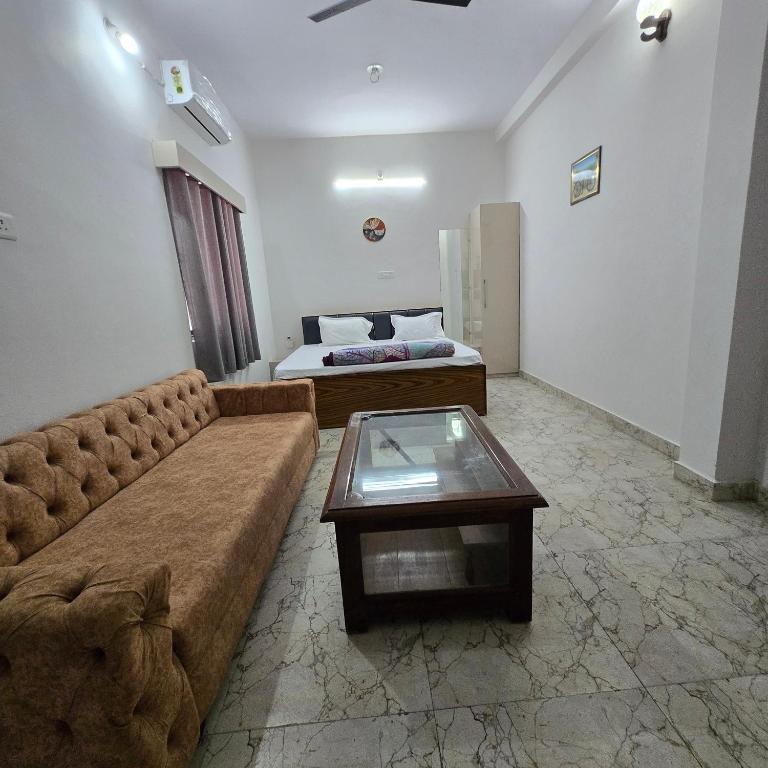 a living room with a couch and a coffee table at Leela homestay - one Bedroom with kitchen in Jabalpur