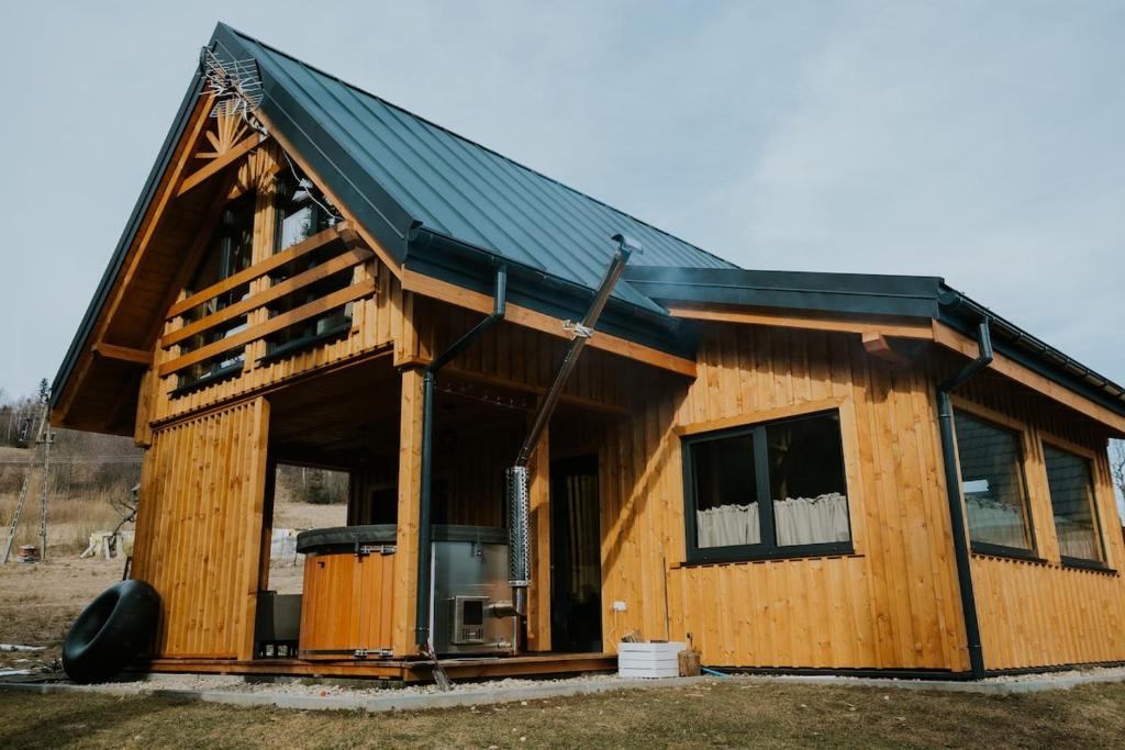 SidzinaにあるDomki Pod Halą Krupowa - Domek Zawojaの黒屋根の大木造家屋