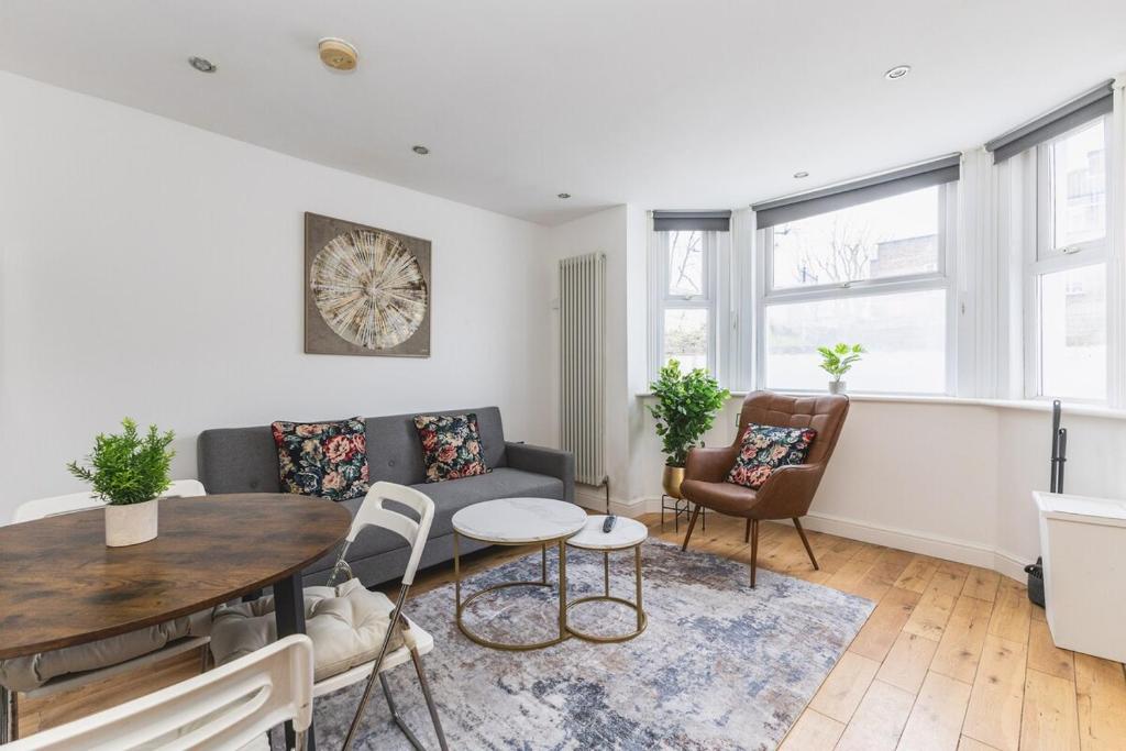 a living room with a couch and a table and chairs at Modern1-Bed - Central Croydon in South Norwood