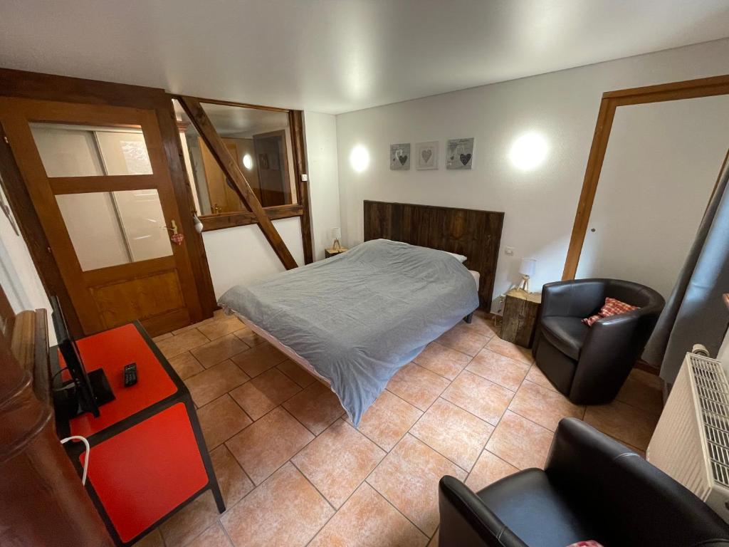 a small bedroom with a bed and a chair at Apartment Cali Elina in Riquewihr