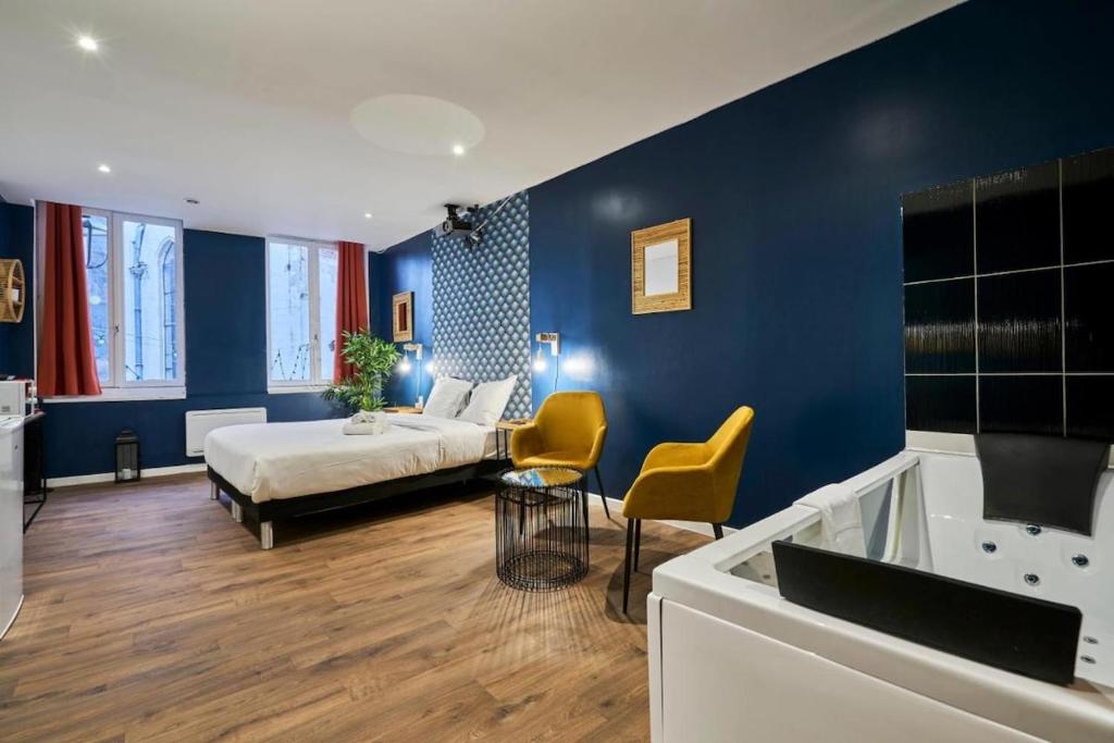 een slaapkamer met een bed en een badkamer met een bad bij Suite Bleue #1#- Élégance & détente-self check-in in Roubaix