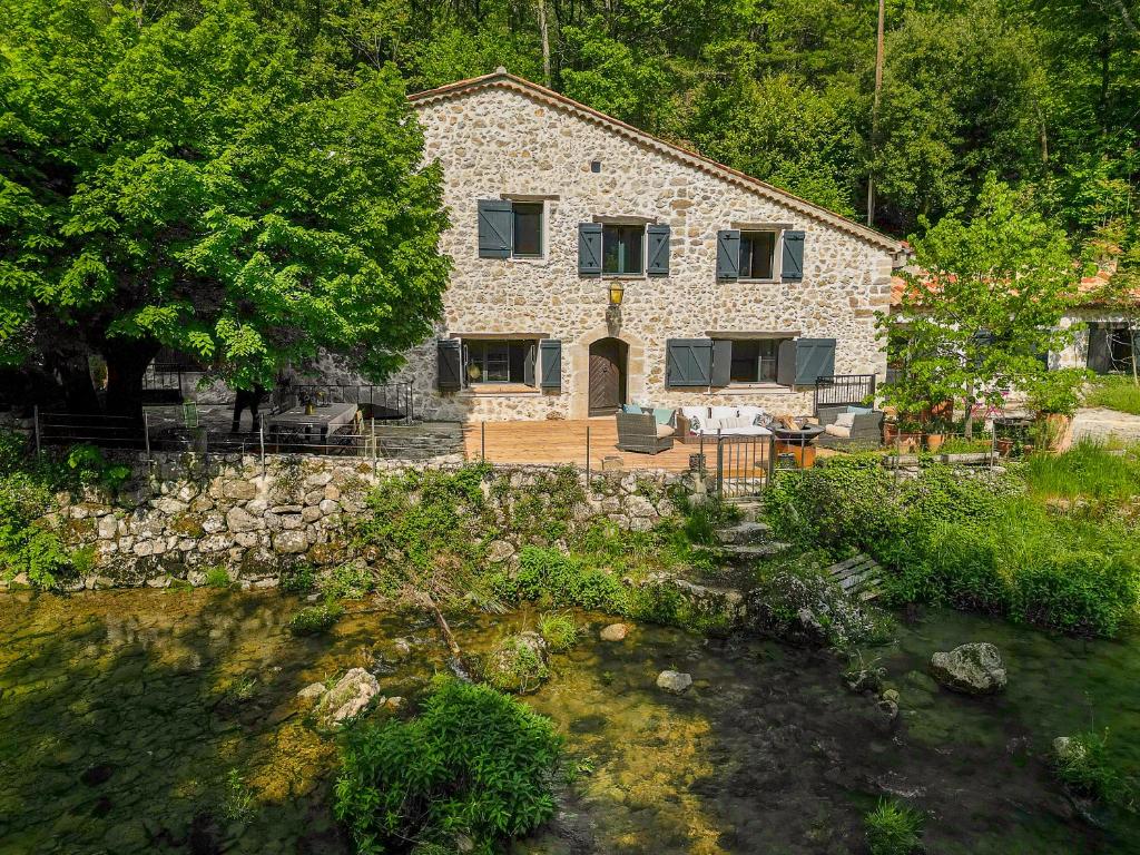 une maison en pierre au milieu d'un jardin dans l'établissement Le Moulin, à Saint-Vallier-de-Thiey