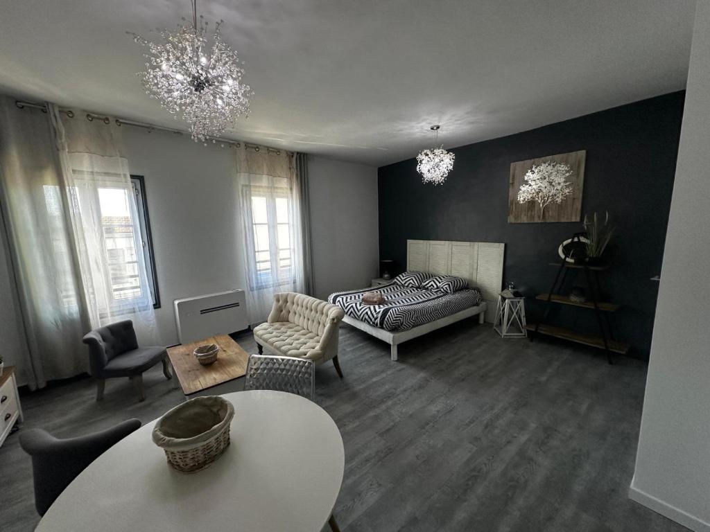 a living room with a couch and a table at Le Caly - 2mn gare SNCF, hyper centre, WIFI-NETFLIX in Niort