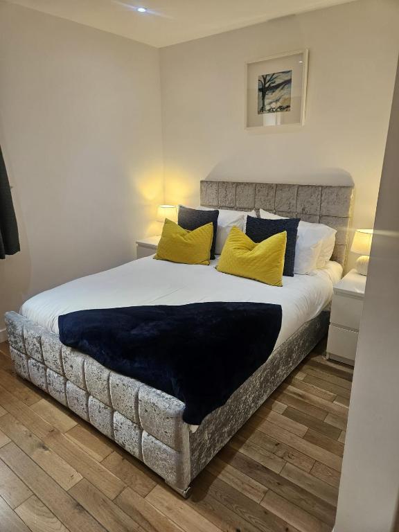 a bedroom with a large bed with yellow pillows at Langley Apartment 2BR Sleeps 4 - great city centre location in Inverness