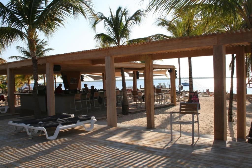 een paviljoen op het strand met een tafel en stoelen bij Eden Beach Resort - Bonaire in Kralendijk