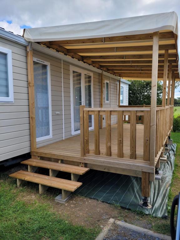 une grande terrasse avec un auvent sur une maison dans l'établissement Stéphanie, à Litteau
