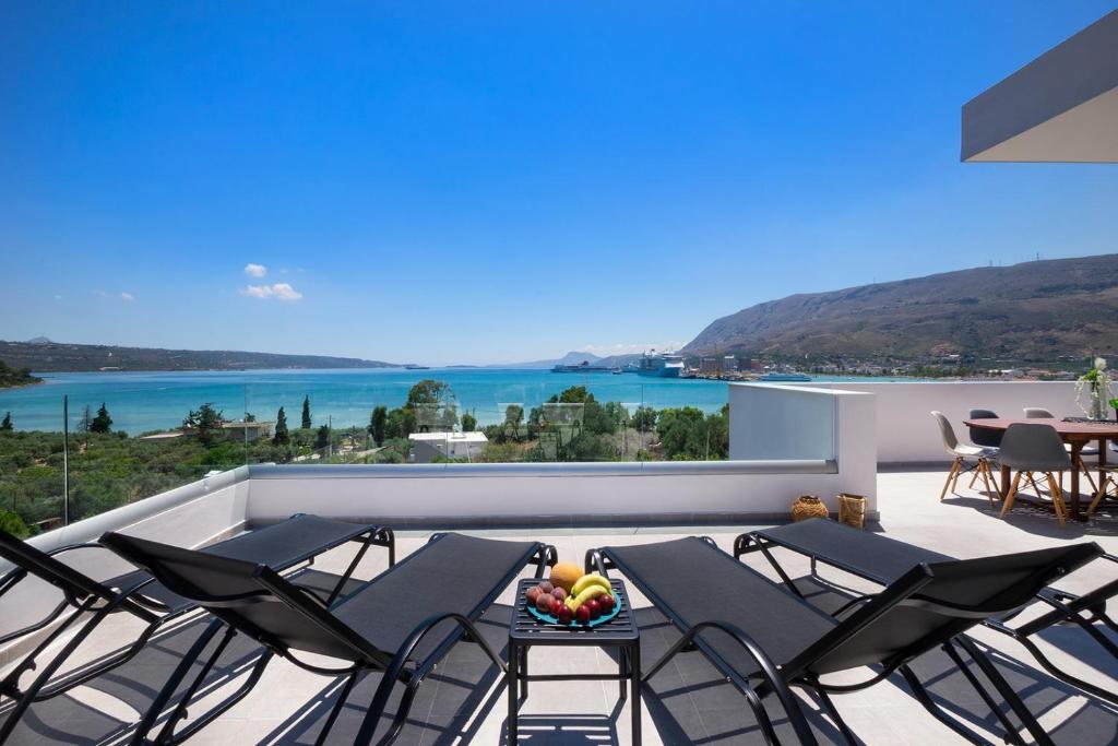 a balcony with chairs and a view of the water at Villa Narciso in Souda