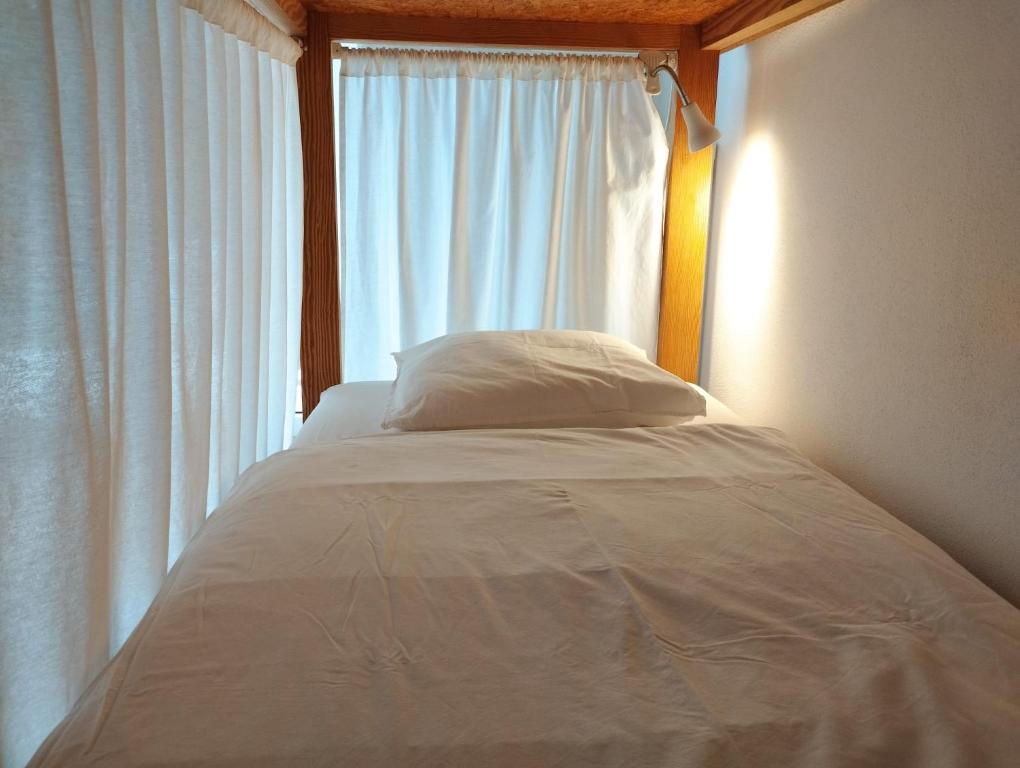 a bed in a room with a window at Endless Summer Surf House in Aljezur
