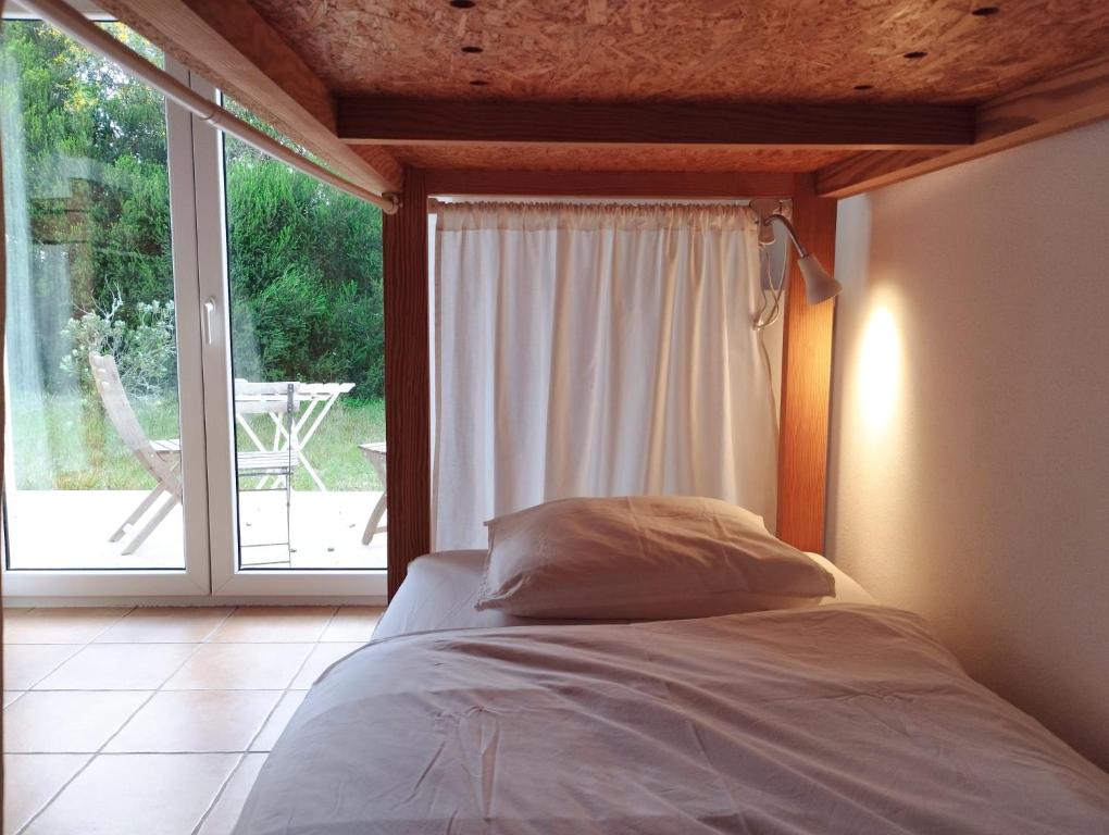 a bedroom with a bed and a large window at Endless Summer Surf House in Aljezur