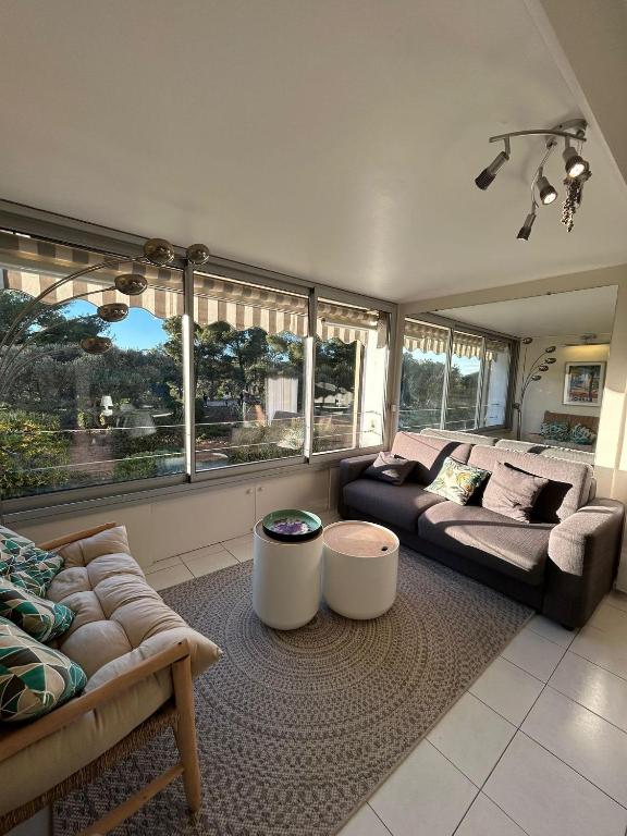 un salon avec deux canapés et une grande fenêtre dans l'établissement Magnifique T2 Athena, à Bandol