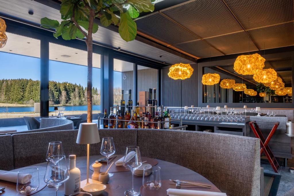a restaurant with a table with wine glasses on it at Anatura Luxembourg in Weiswampach