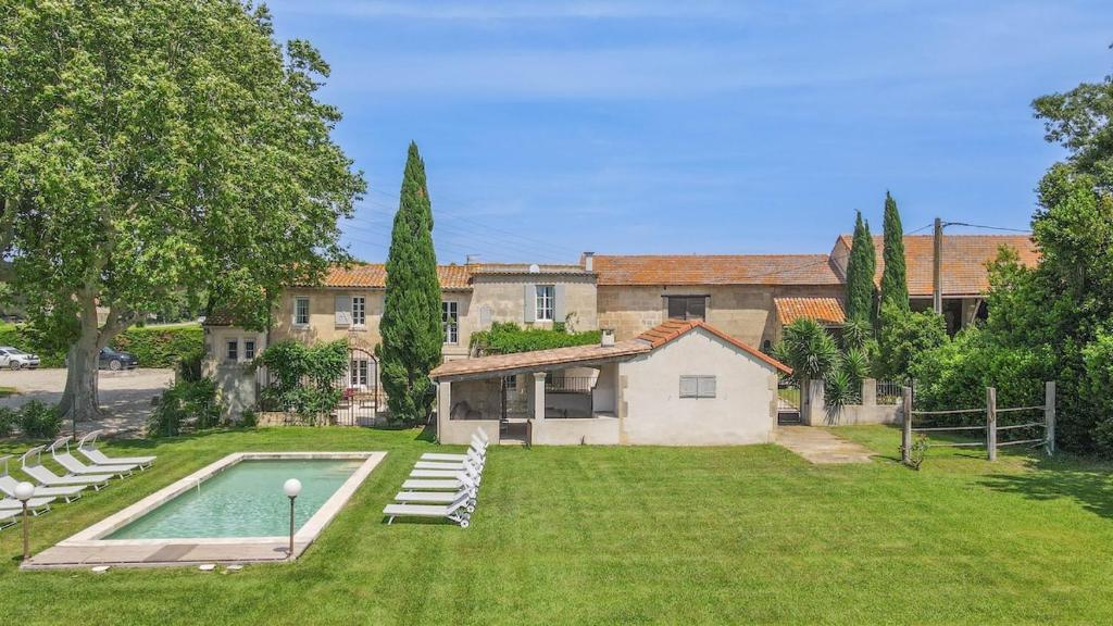 une maison avec une piscine dans une cour dans l'établissement Le Mas des Flammes, à Arles