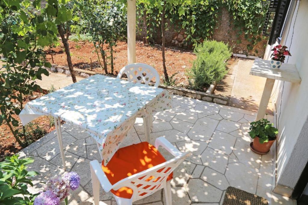 杜布罗夫尼克Apartman Luka的露台上的一张桌子和几把椅子