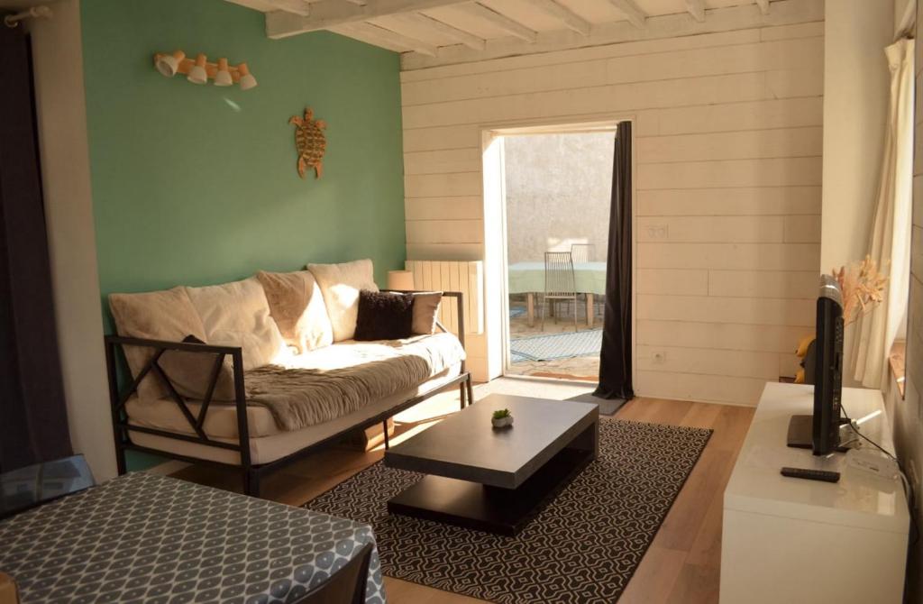 un salon avec un canapé et une table dans l'établissement Blue Cottage, à Plérin