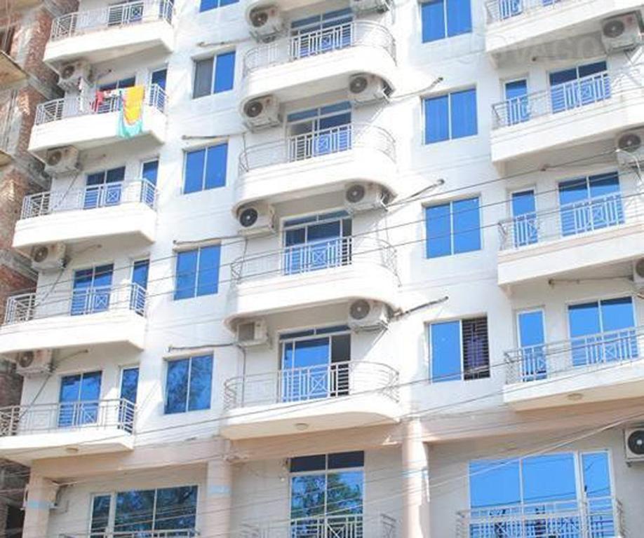 Edificio alto de color blanco con ventanas y balcones en Hotel Sea Alif, en Cox's Bazar