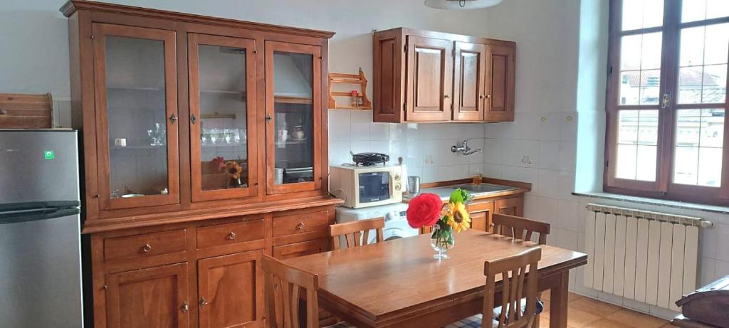 a kitchen with a wooden table with a vase of flowers on it at Casa Vacanze Iris e Aurora in Monti di Licciana Nardi