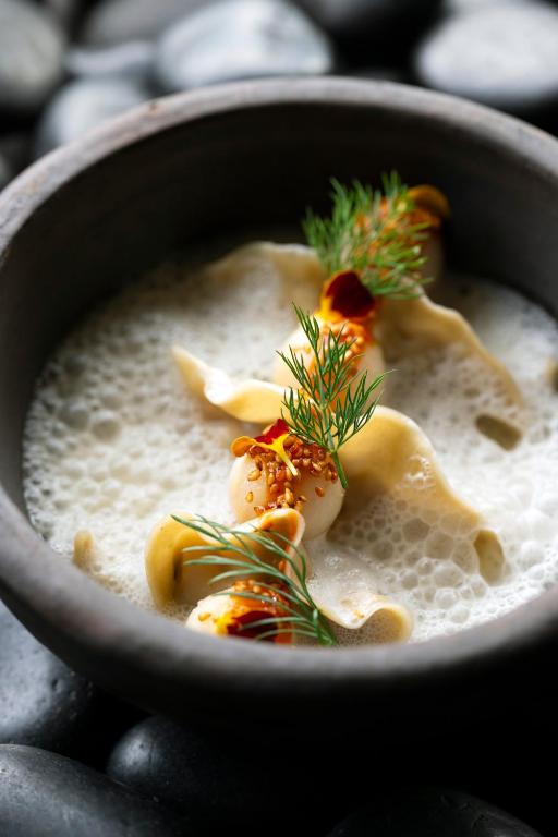 a bowl of soup with shrimp and herbs on top at Anatura Luxembourg in Weiswampach