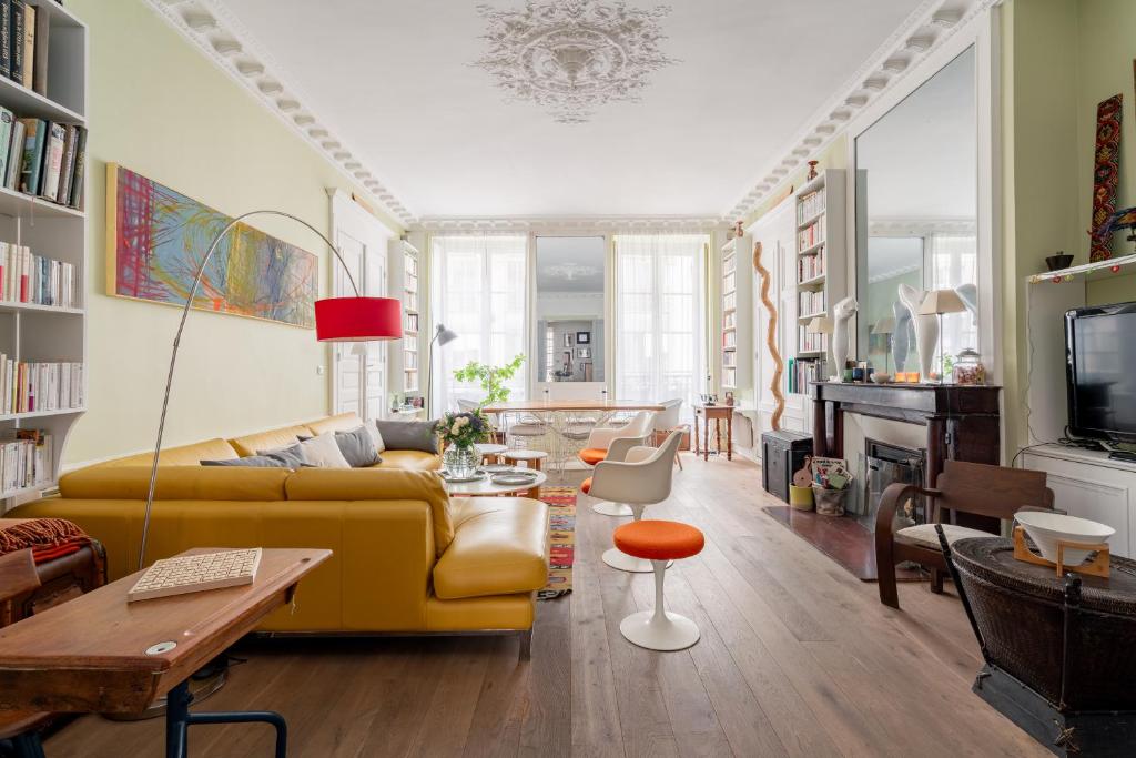 un salon avec un canapé jaune et une table dans l'établissement Veeve - Playful Atelier, à Paris