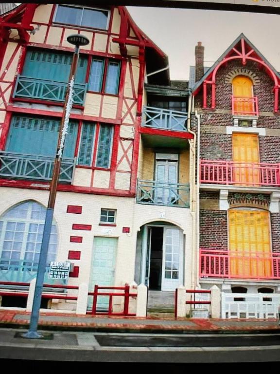 un bâtiment rouge et blanc au bord d'une rue dans l'établissement Studio classé 2 étoiles avec entrée face à la mer dans immeuble Belle Époque, au Tréport