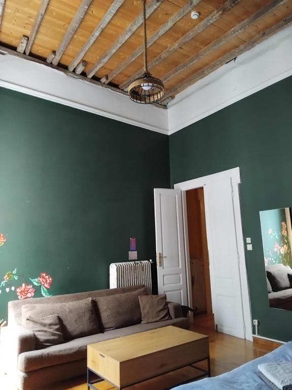 un soggiorno con un divano e pareti verdi di The monumental house ad Atene