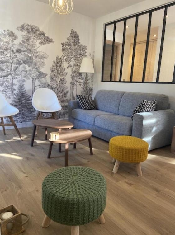 un salon avec un canapé bleu et des tables dans l'établissement Saint Jorioz, Cozy appartement tout près du lac, à Saint-Jorioz