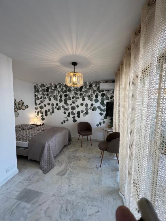 une chambre avec un lit et un lustre dans l'établissement Studio Cannes Californie, à Cannes