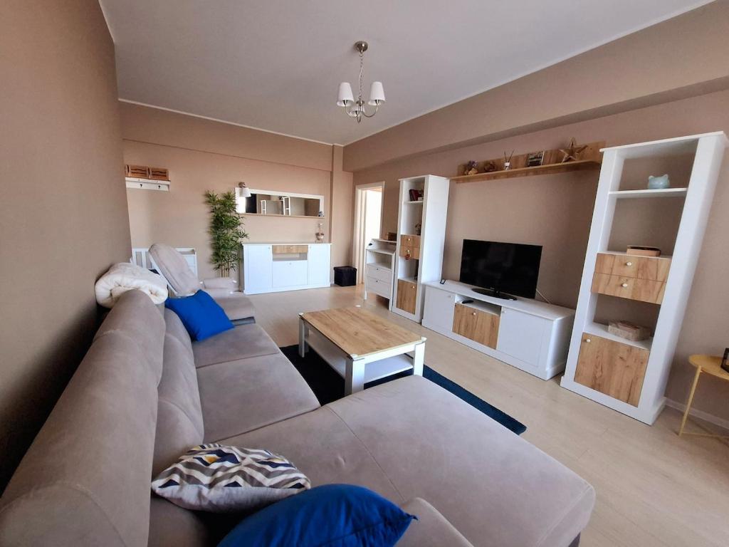 a living room with a couch and a television at Homey Apartment Vacaresti in Bucharest