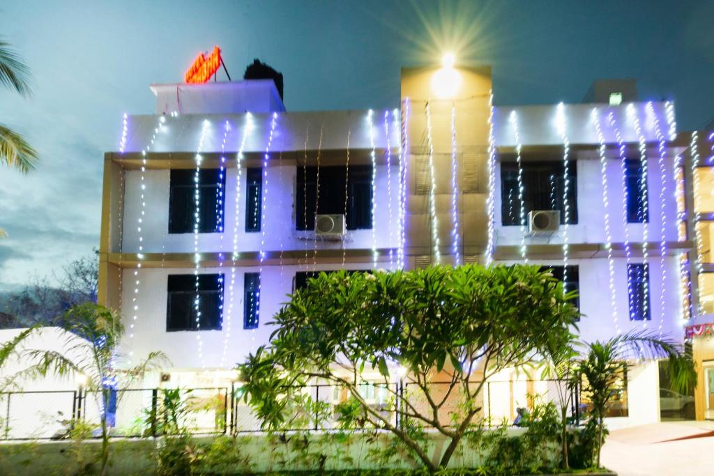 a white building with christmas lights on it at Hotel O Shivprabha in Boisar