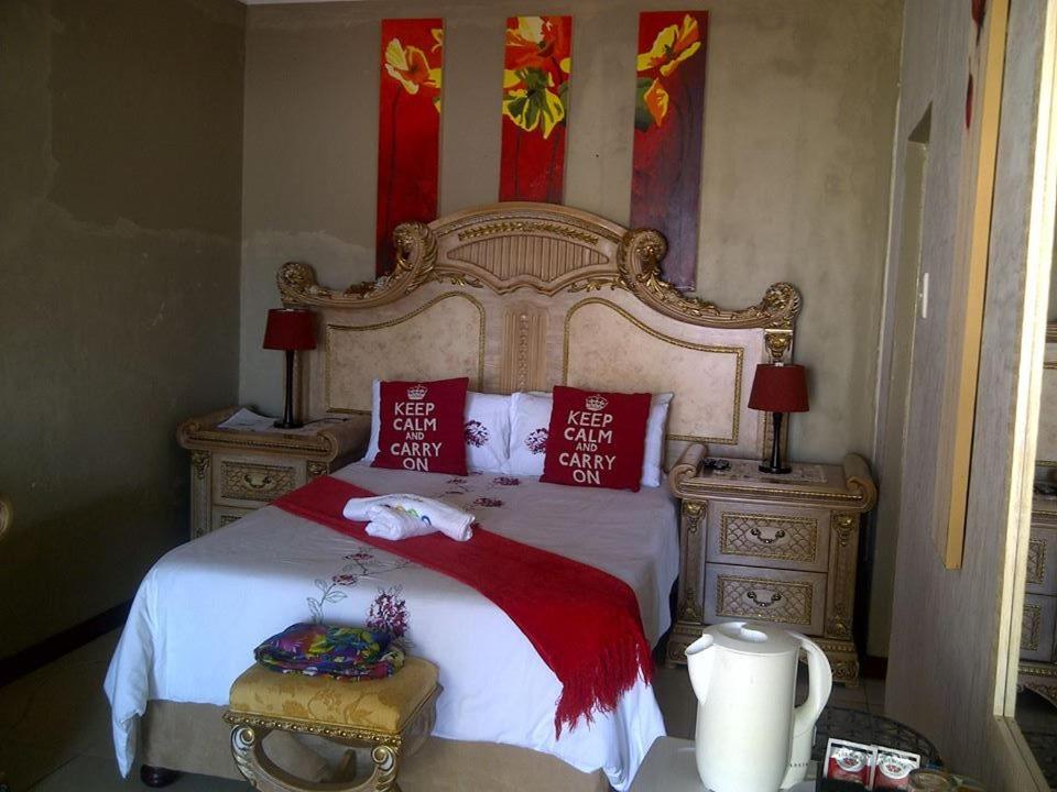 Un dormitorio con una cama grande con almohadas rojas. en The Rest Place Bed & Breakfast, en East London