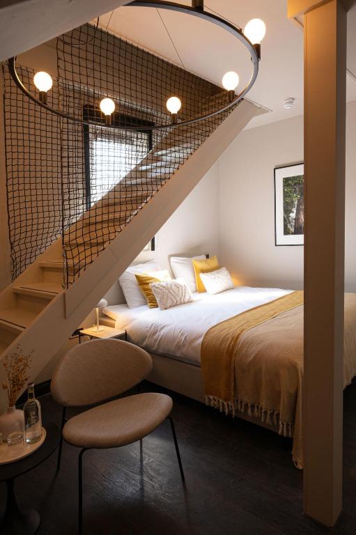 een slaapkamer met een groot bed en een trap bij Boutique Hotel Kint in Valkenburg