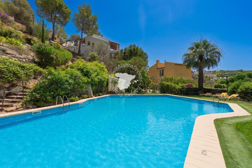 een zwembad in een tuin met bomen en een huis bij CostaBlancaDreams Casa Altea in Altea in Alicante