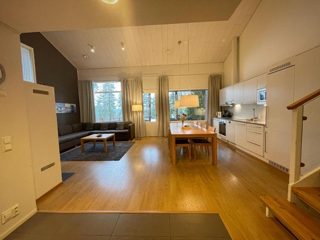 a large living room with a table and a kitchen at Kylpyla Spa Villa 504 Saimaan Harmonia in Imatra