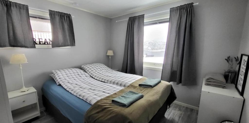 a bedroom with a bed with two towels on it at Perfect apartment for whale safari at Skjervøy! in Skjervøy