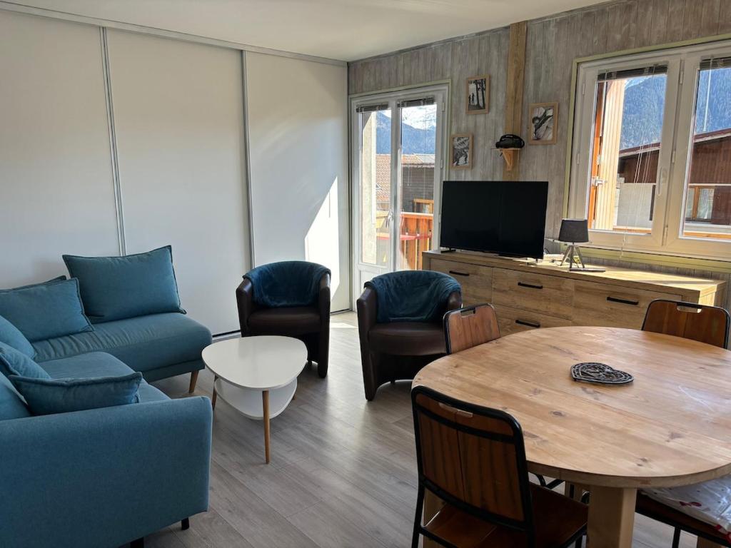 un salon avec un canapé bleu et une table dans l'établissement Le Pin I T2, à Passy