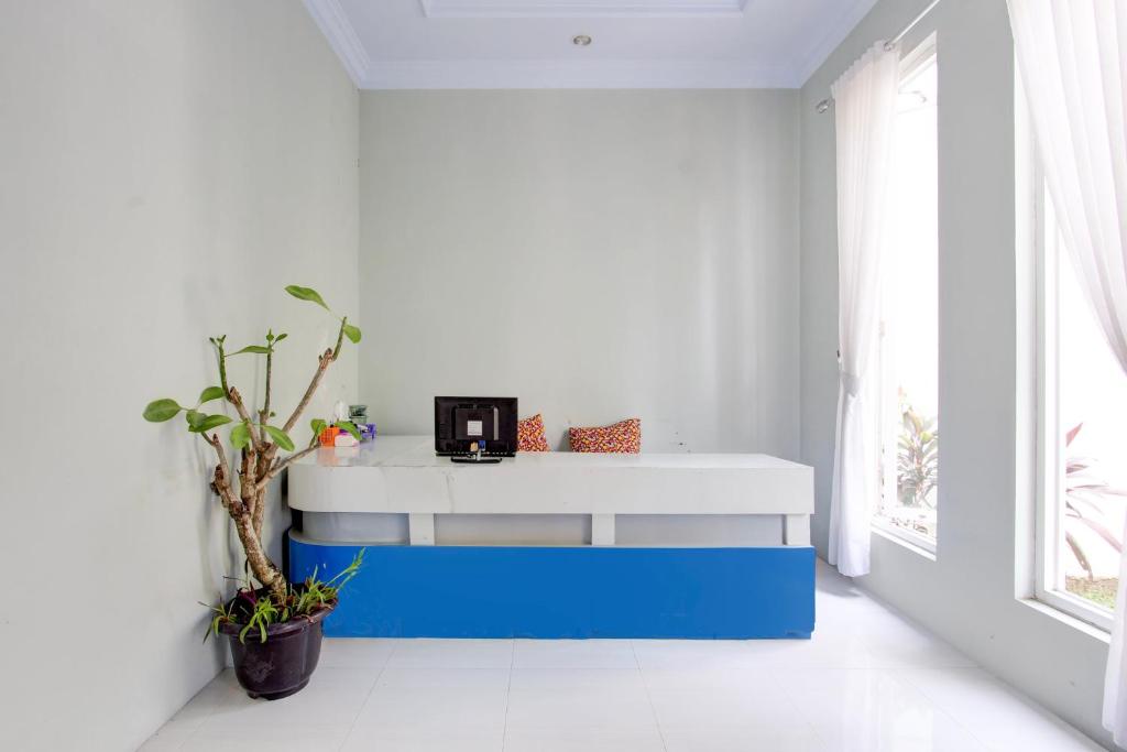 a white and blue counter in a room with a window at Hotel O D'draman Homestay Syariah in Wanujoyo