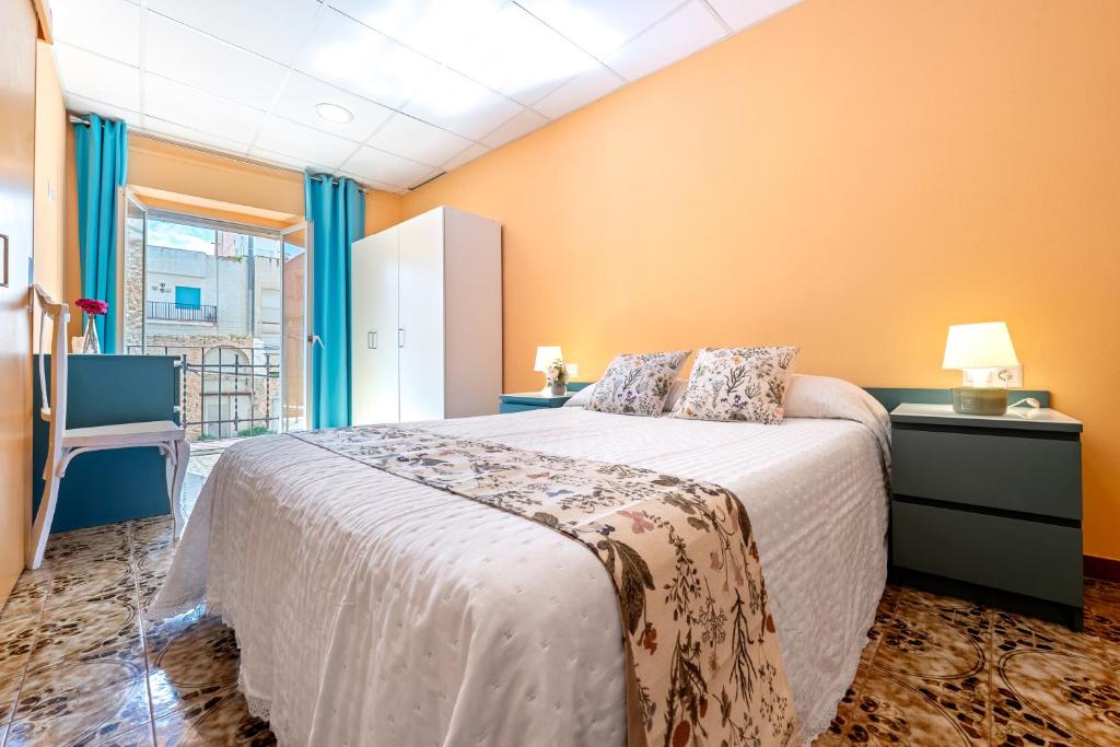 a bedroom with a large bed with orange walls at Loft Sant Joan in L'Ametlla de Mar