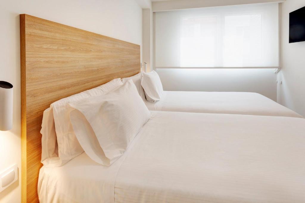 Postel nebo postele na pokoji v ubytování Sercotel Logroño Suites