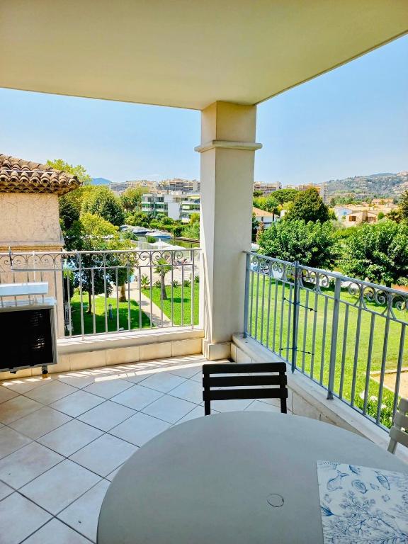 - un balcon avec une table et une vue dans l'établissement Appartement 221 - LES SUITES DE ROBINSON - Résidence avec piscine en bord de Siagne, à Mandelieu-La-Napoule, à Mandelieu-la-Napoule