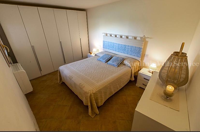 a bedroom with a bed with blue pillows at Villetta Belvedere con Jacuzzi in Porto Cervo