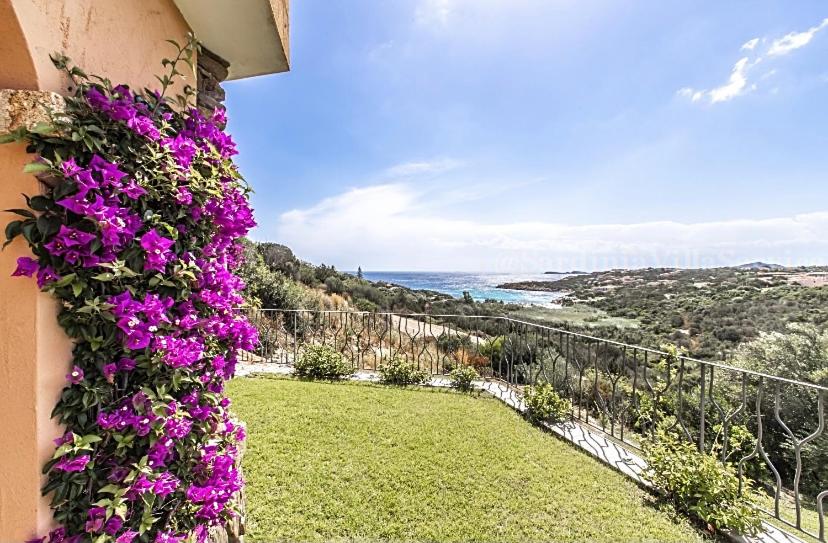a building with purple flowers on the side of it at Villetta Belvedere con Jacuzzi in Porto Cervo