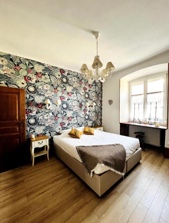 - une chambre avec un grand lit et un mur fleuri dans l'établissement Schmoutzi & Schatzi - Au cœur de la ville, à Colmar