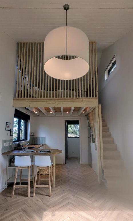 une pièce avec un escalier, une table et des chaises dans l'établissement Tiny Tranquille, à Sailly-lès-Lannoy