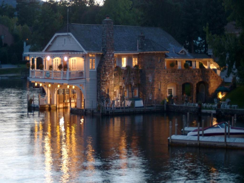a large house on the water at night at Lake George Boathouse Waterfront Lodging in Bolton Landing