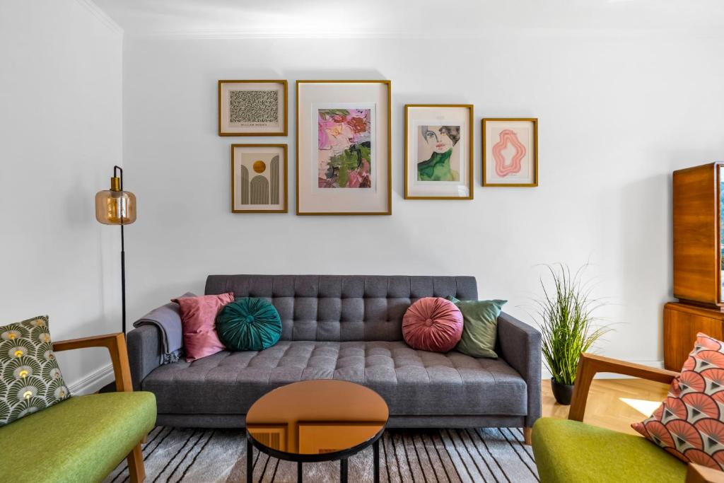 a living room with a gray couch with colorful pillows at Wola Ratusz Serene Apartment by BookingHost in Warsaw