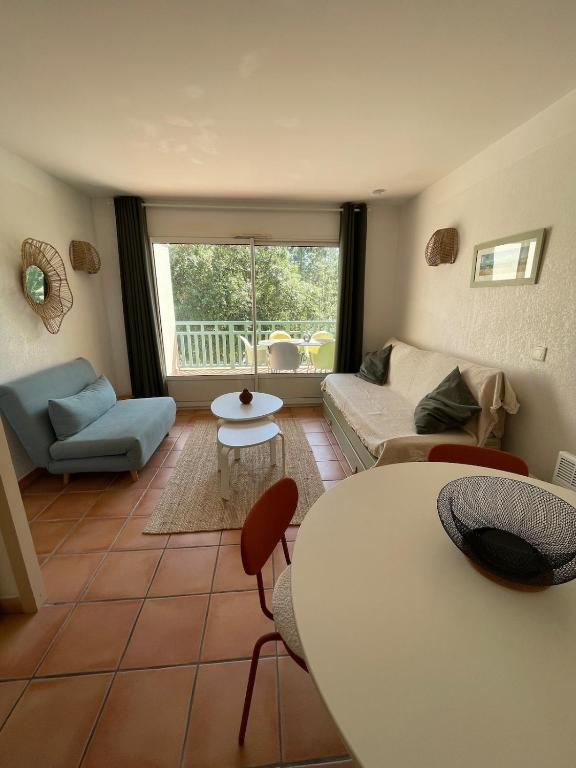 un salon avec un canapé et une table dans l'établissement Séjour Piscine, Forêt, Océan à Soustons Plage, à Soustons