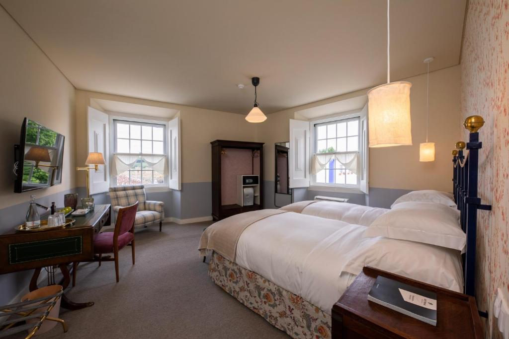 a large bedroom with a large bed and a desk at Pousada Vila Óbidos in Óbidos