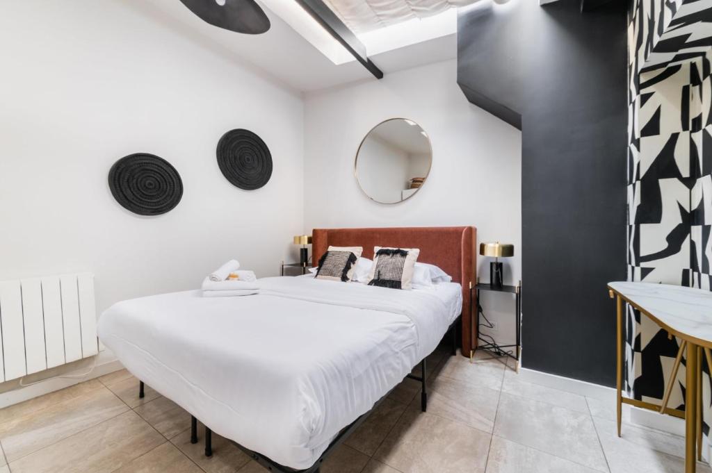 une chambre avec un grand lit et un miroir dans l'établissement 2 pieces Belleville refait neuf 6 pers - paris 19, à Paris