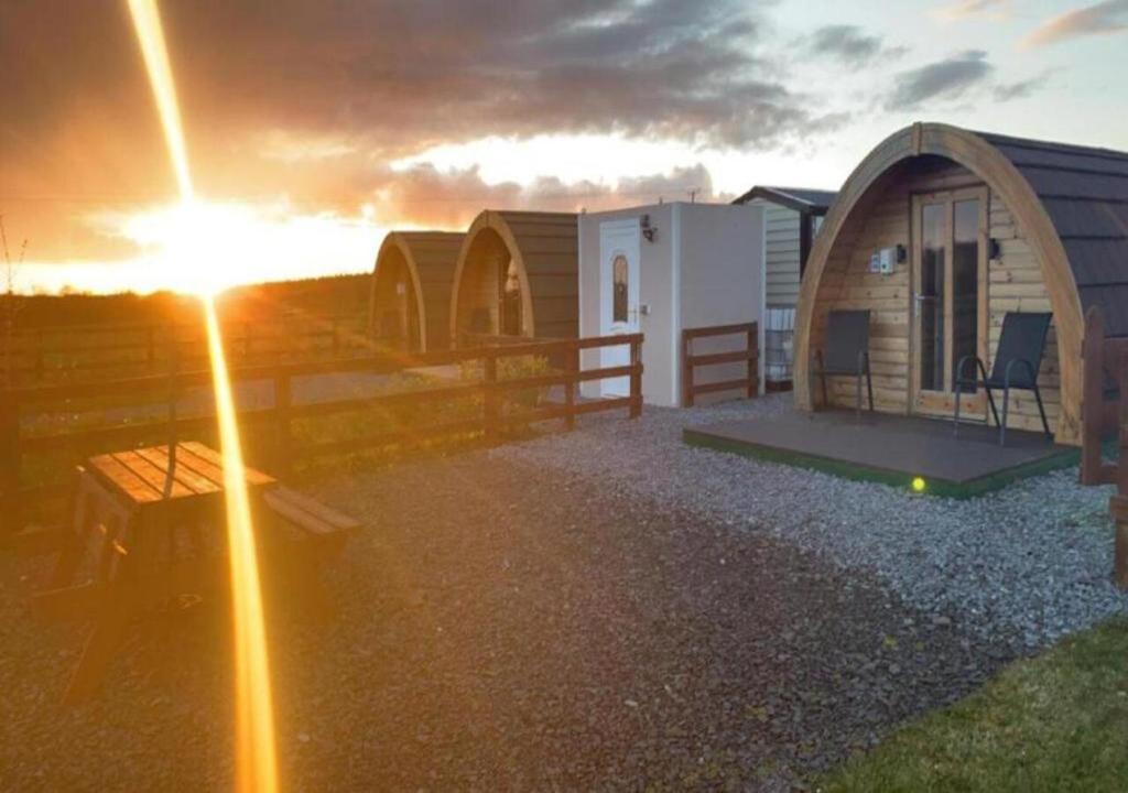 un gruppo di piccole case con il tramonto di Emlagh, Self Catering Glamping Pods a Kilkee