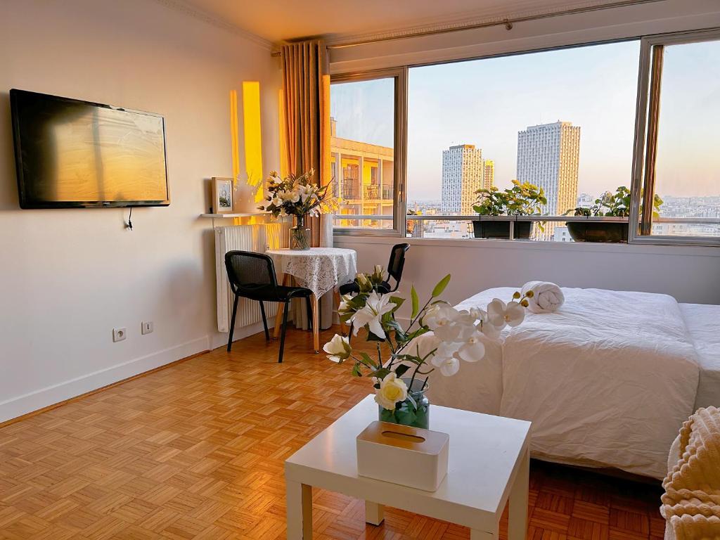 - une chambre avec un lit et une table fleurie dans l'établissement Large charming studio in Paris, à Paris