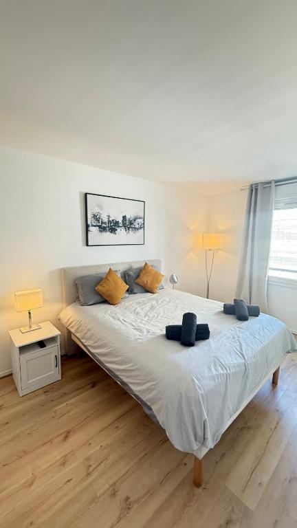 une chambre avec un grand lit avec des oreillers bleus dessus dans l'établissement Appartement moderne au centre-ville de Villeneuve La Garenne, à Villeneuve-la-Garenne